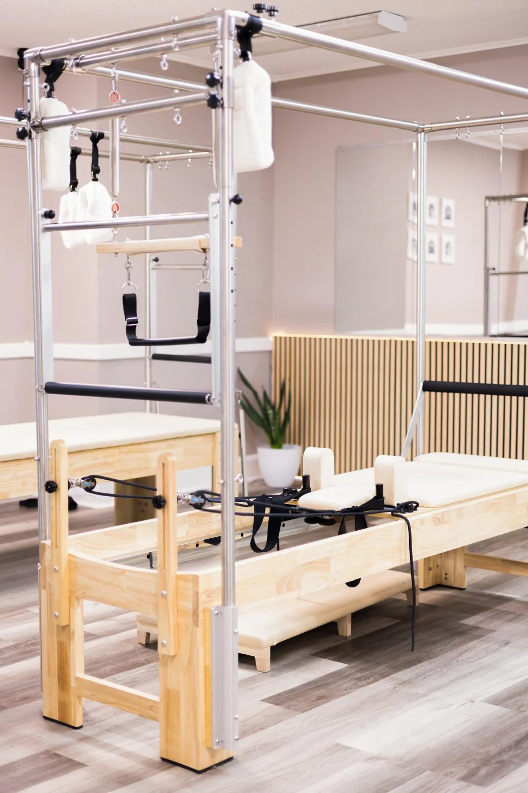 Cadillac (mesa de trapézio) e Reformer na sala principal iluminada do Inspire Pilates Studio