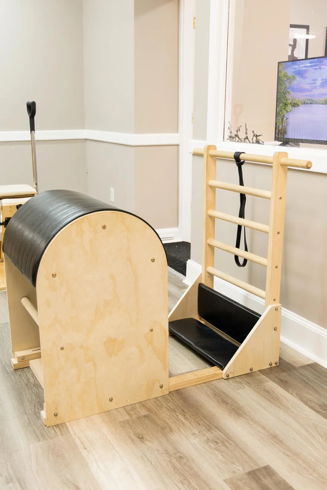 Ladder Barrel encostado na parede de uma sala de Pilates bem iluminada