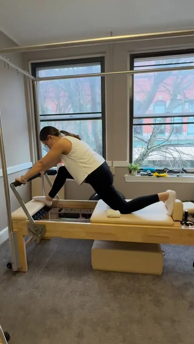 Client doing a lunge on the Reformer during a private Pilates session in Lowell