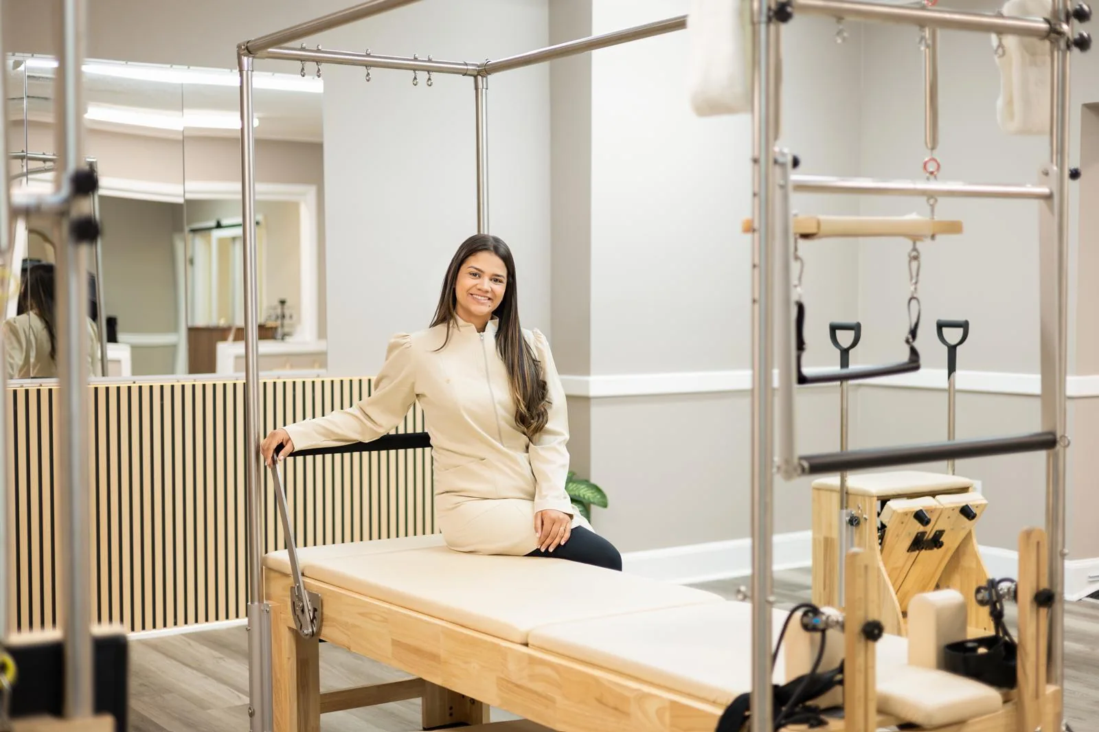 Bruna Felix Costa sentada en un Cadillac (mesa trapecio) en la sala principal de Pilates